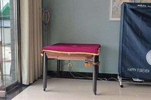 A room with a table covered by a red cloth, a curtain, a wall-mounted speaker, and a framed picture. - Taining Dajinhu Xiuzhen Homestay (Taining)