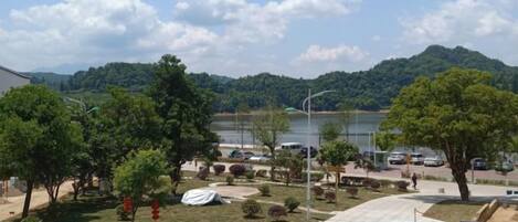 A view of a parking area with a lake and hills in the background.