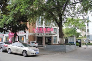 A hotel with a red sign, parked cars, and a tree in front. - AA Room Hotel (Shanghai Donglin Temple) (Shanghai)