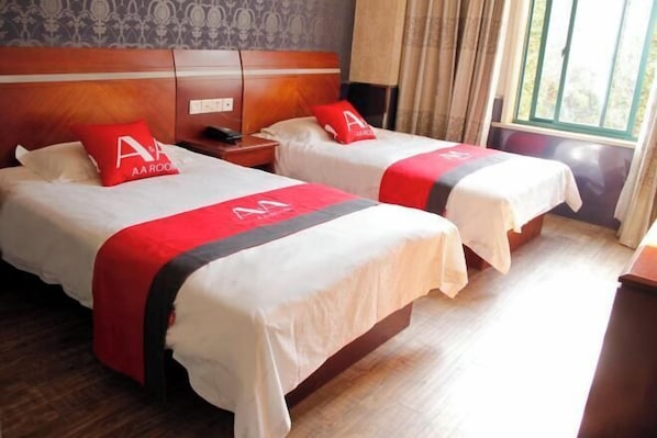 Two double beds with red and white bedding, a wooden headboard, a nightstand with a phone, and a window with curtains. - AA Room Hotel (Shanghai Donglin Temple) (Shanghai)