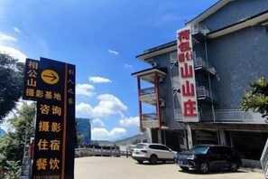 Un hôtel doté d’une enseigne indiquant la présence d’installations telles qu’un restaurant et offrant une vue sur la montagne.