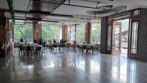 A spacious dining area with tables and chairs, large windows, and a modern ceiling design. - Yangshuo Xianggong Mountain Villa (Xianggong Mountain Scenic Area Store) (Yangshuo)