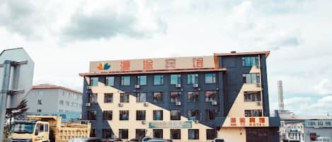 A multi-story building with a modern architectural design, featuring a prominent sign at the top.