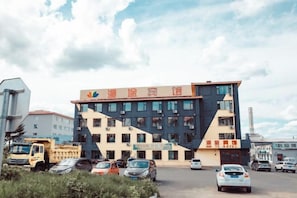 A multi-story building with a modern architectural design, featuring a prominent sign at the top. - Yichun Mantu Hotel (Yichun)