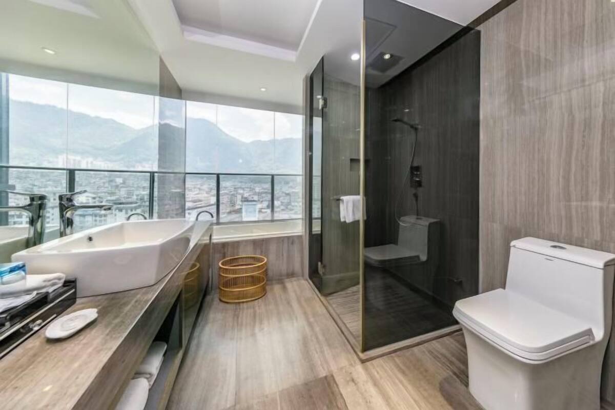 Un baño moderno con bañera, inodoro y ducha con mampara de vidrio.
