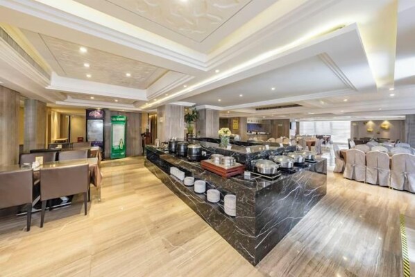 Un hall d’hôtel doté d’un comptoir d’accueil en marbre, d’un espace salon et d’un buffet.
