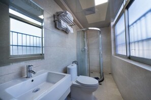 A modern bathroom with a sink, toilet, and glass shower enclosure. - Xinxing Business Hotel (Wuyishan)