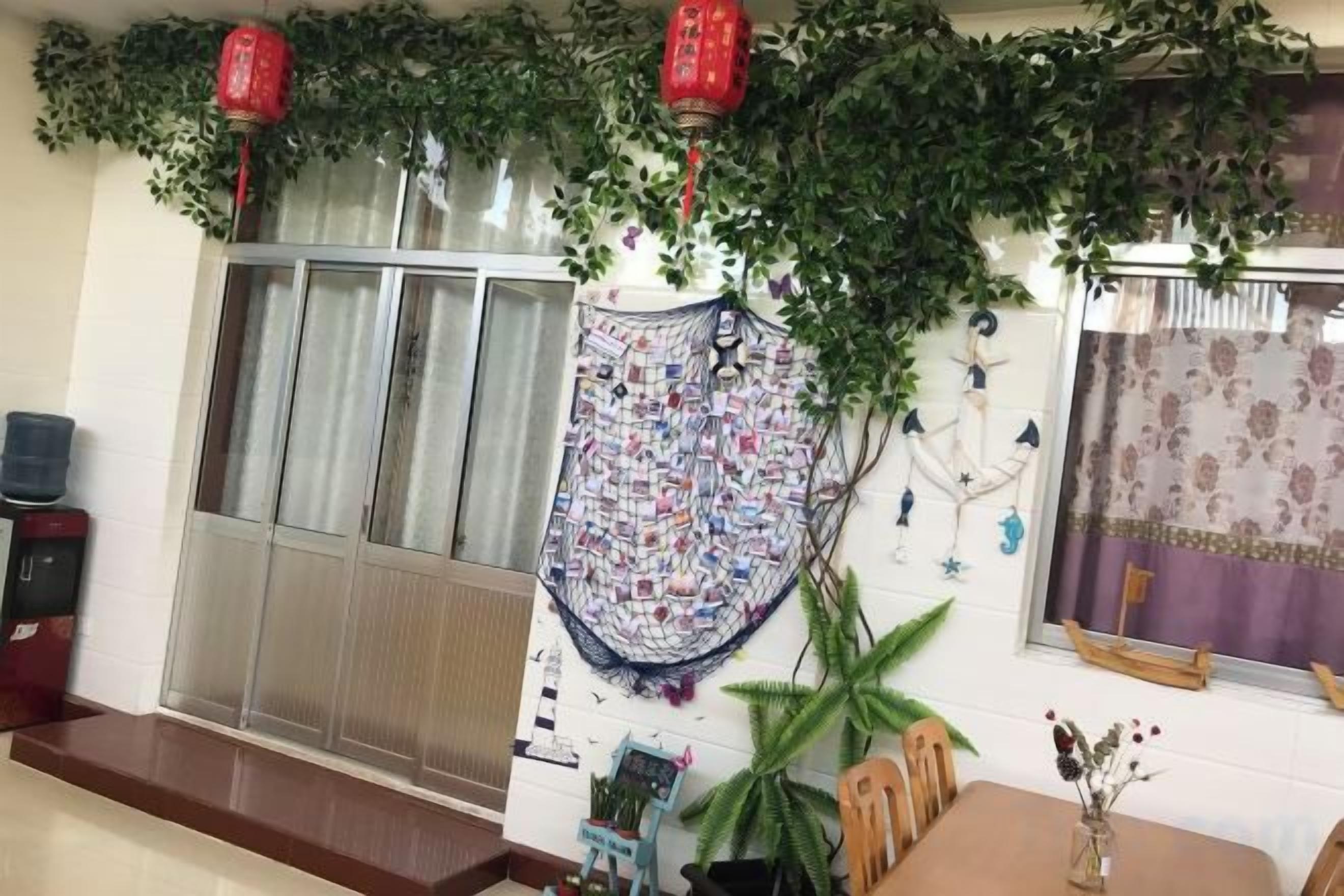 A room with a sliding glass door, a patterned wall hanging, and a potted plant.
