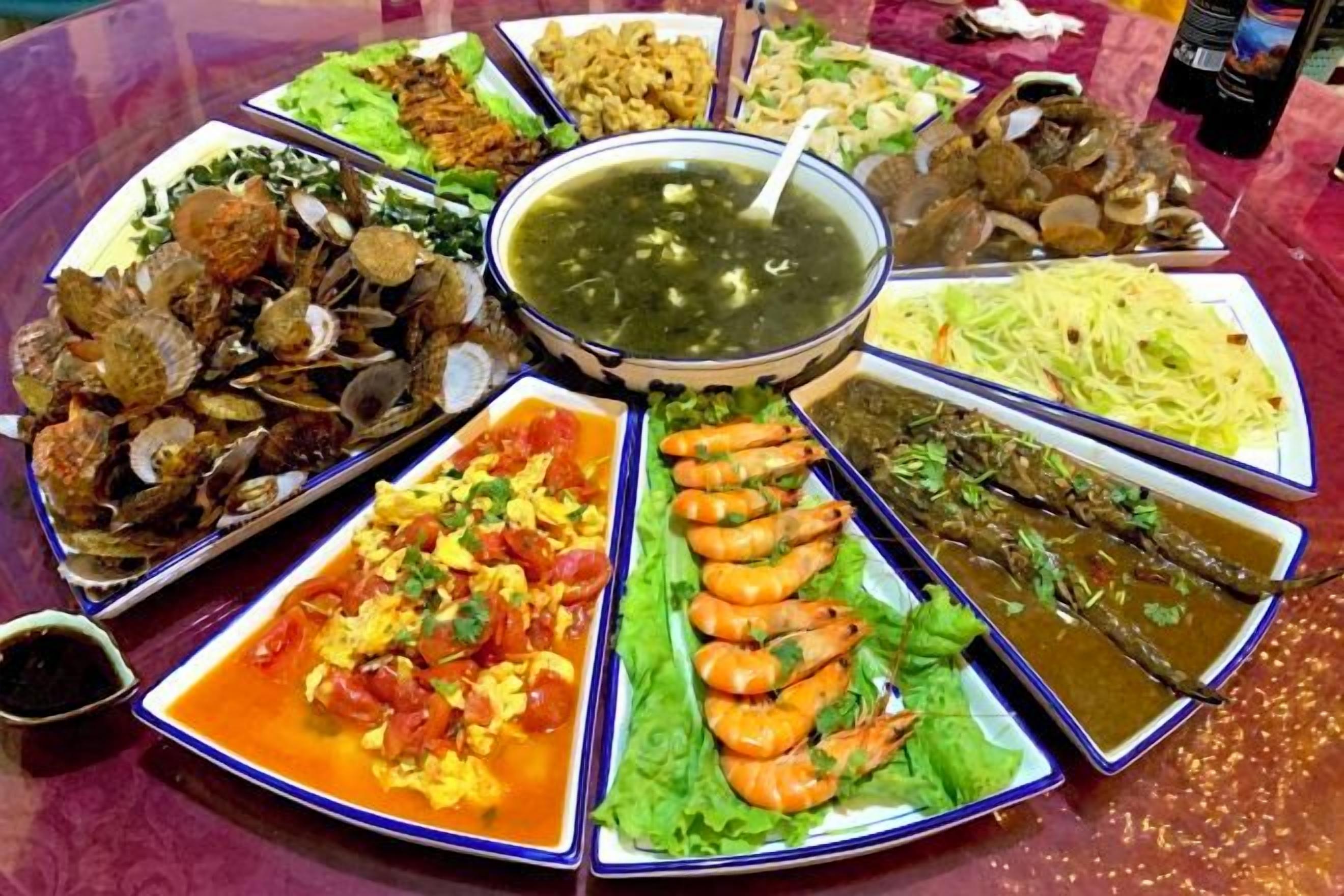 A table with various dishes arranged around a central bowl, likely for a communal meal.