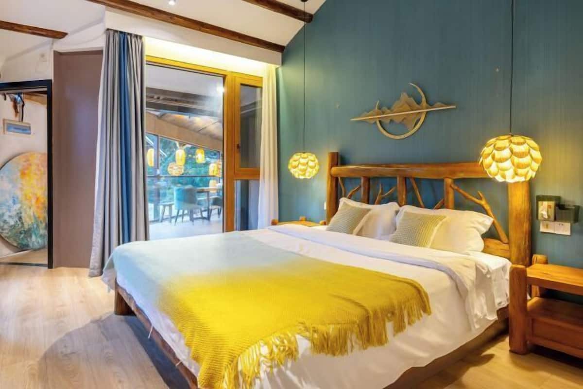 Een slaapkamer met een groot bed, een houten hoofdeinde en twee wandlampen.