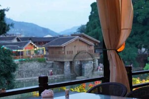 Una mesa con vistas a edificios tradicionales y un puente de piedra al fondo.