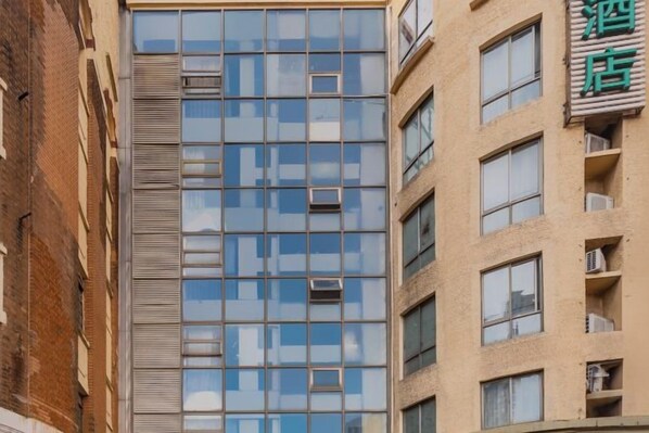 A modern building with a glass facade and multiple windows. - Motel (The Bund, Qipu Road, Tiantong Road Metro Station) (Shanghai)