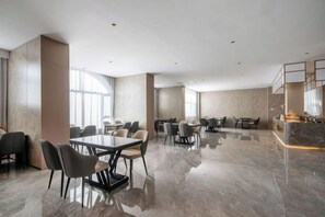 A spacious hotel conference room with multiple tables and chairs, a marble floor, and large windows. - Starway Hotel (Liaocheng Zhenxing West Road) (Liaocheng)