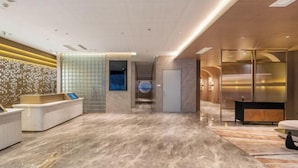 A modern hotel lobby with a reception desk, a glass wall, and a marble floor. - Starway Hotel (Liaocheng Zhenxing West Road) (Liaocheng)