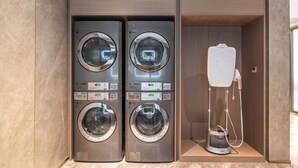 A modern laundry room with four stacked front-loading washing machines and a standalone dryer. - Starway Hotel (Liaocheng Zhenxing West Road) (Liaocheng)
