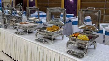 Una mesa de buffet con diferentes recipientes de comida y utensilios.