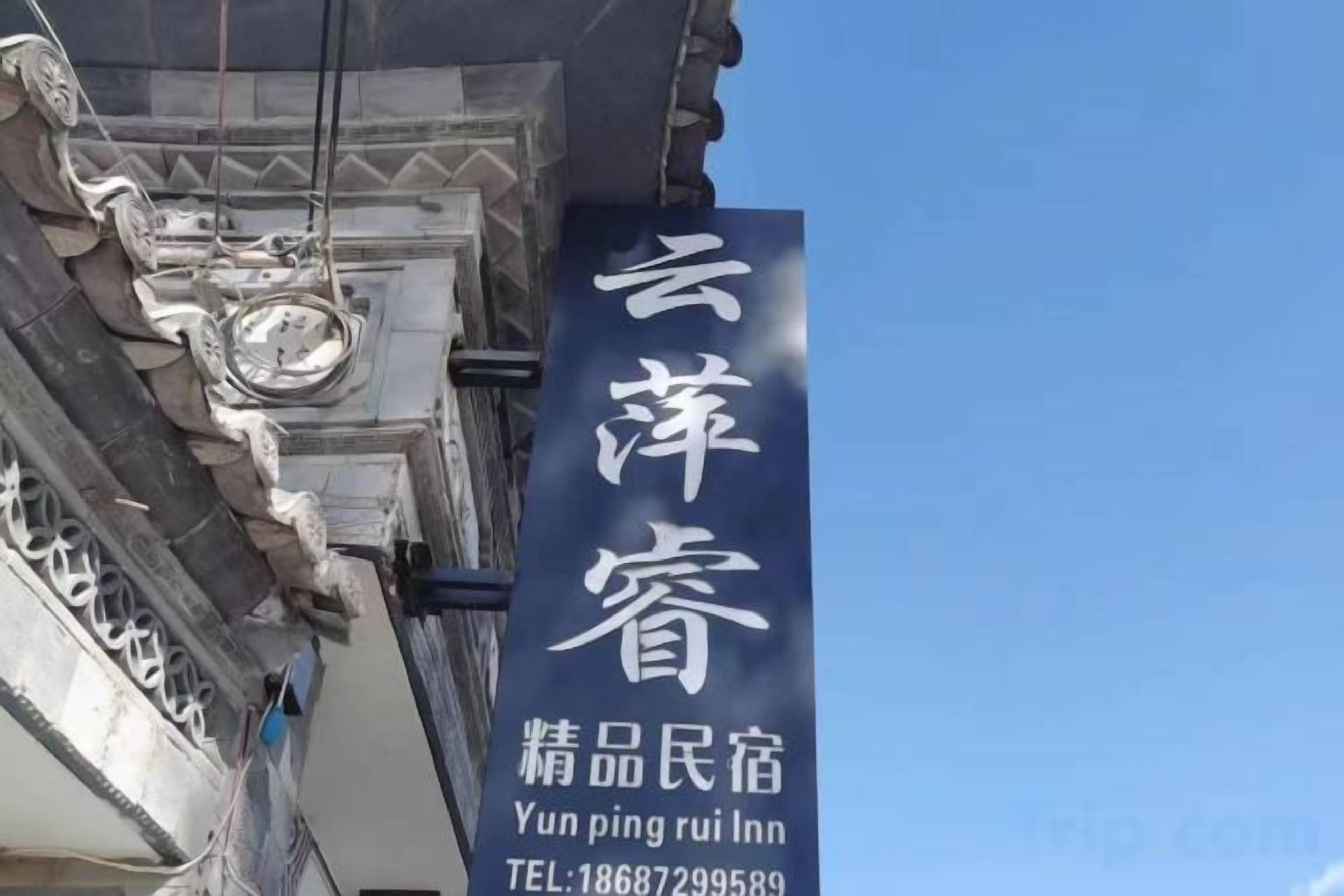 A sign with Chinese characters and English text for a hotel named 'Yunping Rui Inn.'