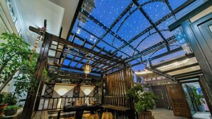 A cozy indoor garden with a wooden pergola, a table, and potted plants. - Dali Yunpingrui Boutique Homestay (Dali City)