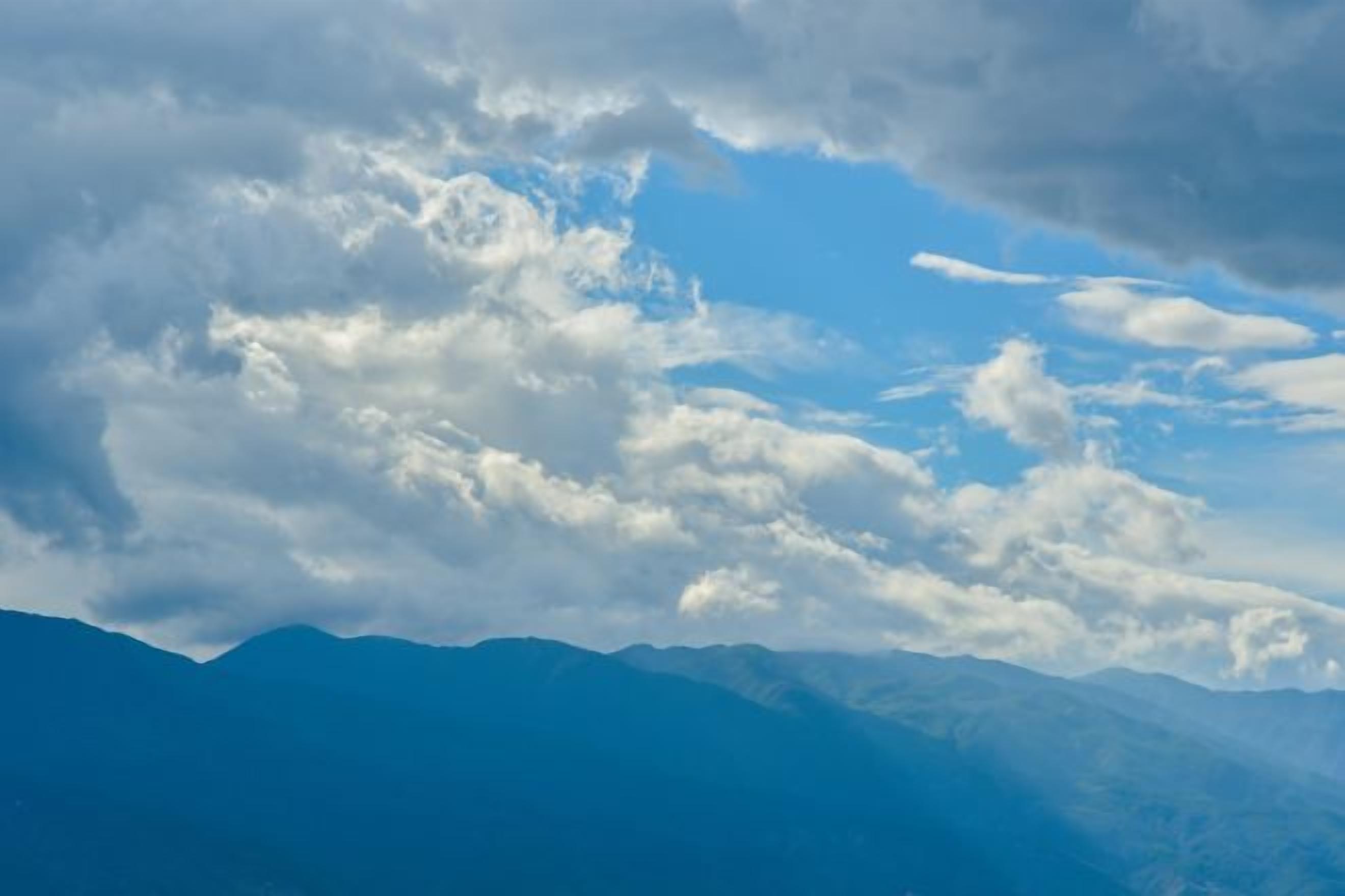 A mountain range with a clear sky and clouds.