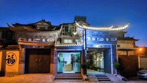 A traditional building with a prominent entrance, a staircase leading up to the door, and a sign with Chinese characters. - Dali Yunpingrui Boutique Homestay (Dali City)