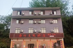 Un edificio de varios pisos con un letrero rojo en la entrada.