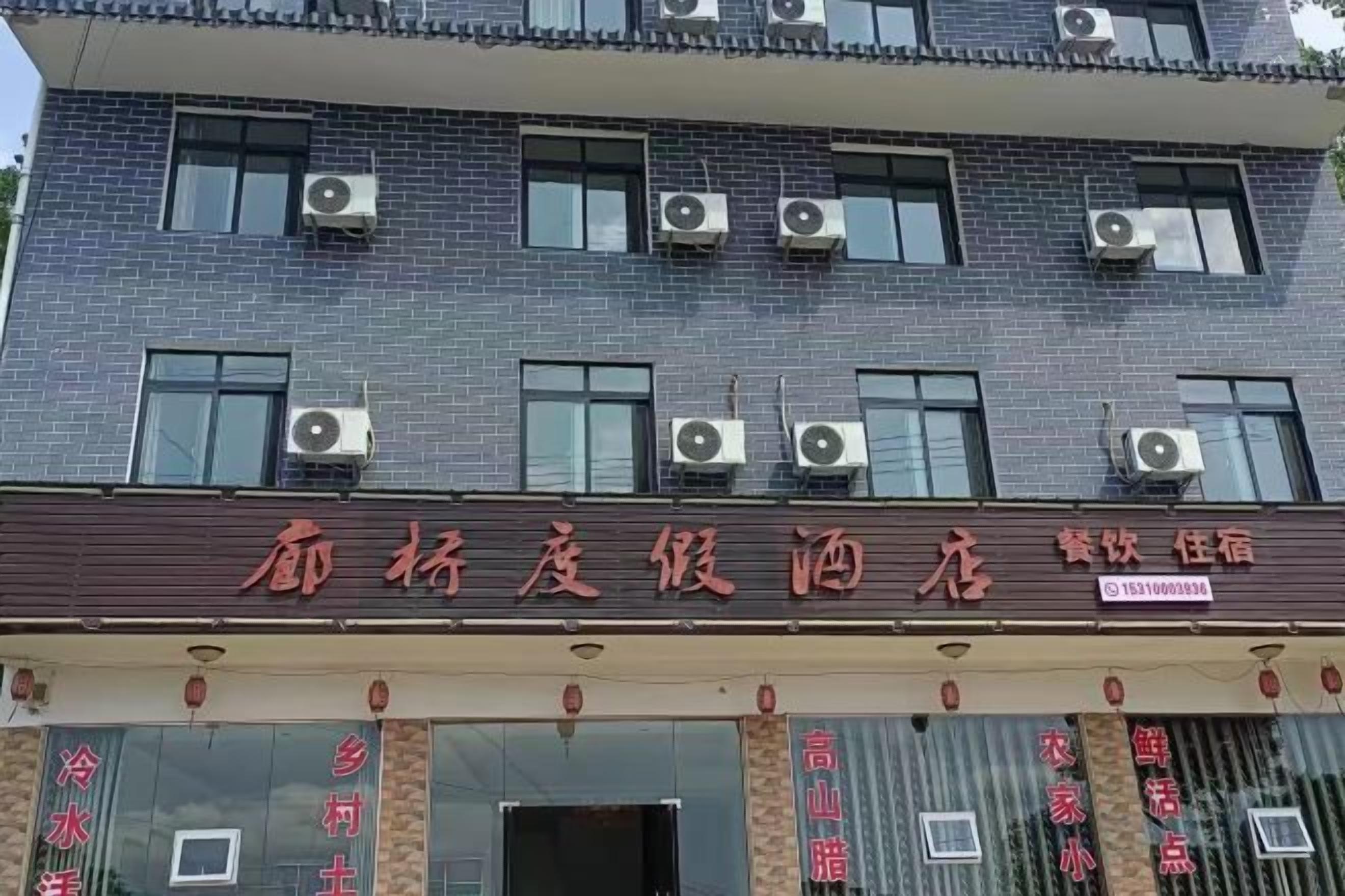 Ein Hotel mit mehreren Klimaanlagen, einer Schautafel mit chinesischen Schriftzeichen und einer Schaufensterdekoration mit verschiedenen Artikeln.
