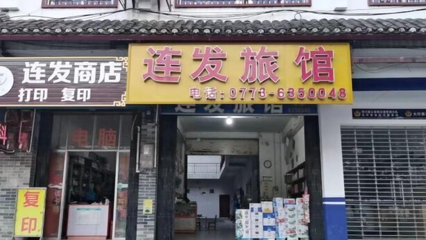 A storefront with a sign for a travel agency and a printing service. - Lianfa Guesthouse (Lingchuan)
