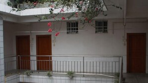 A multi-level building with balconies, wooden doors, and potted plants. - Lianfa Guesthouse (Lingchuan)