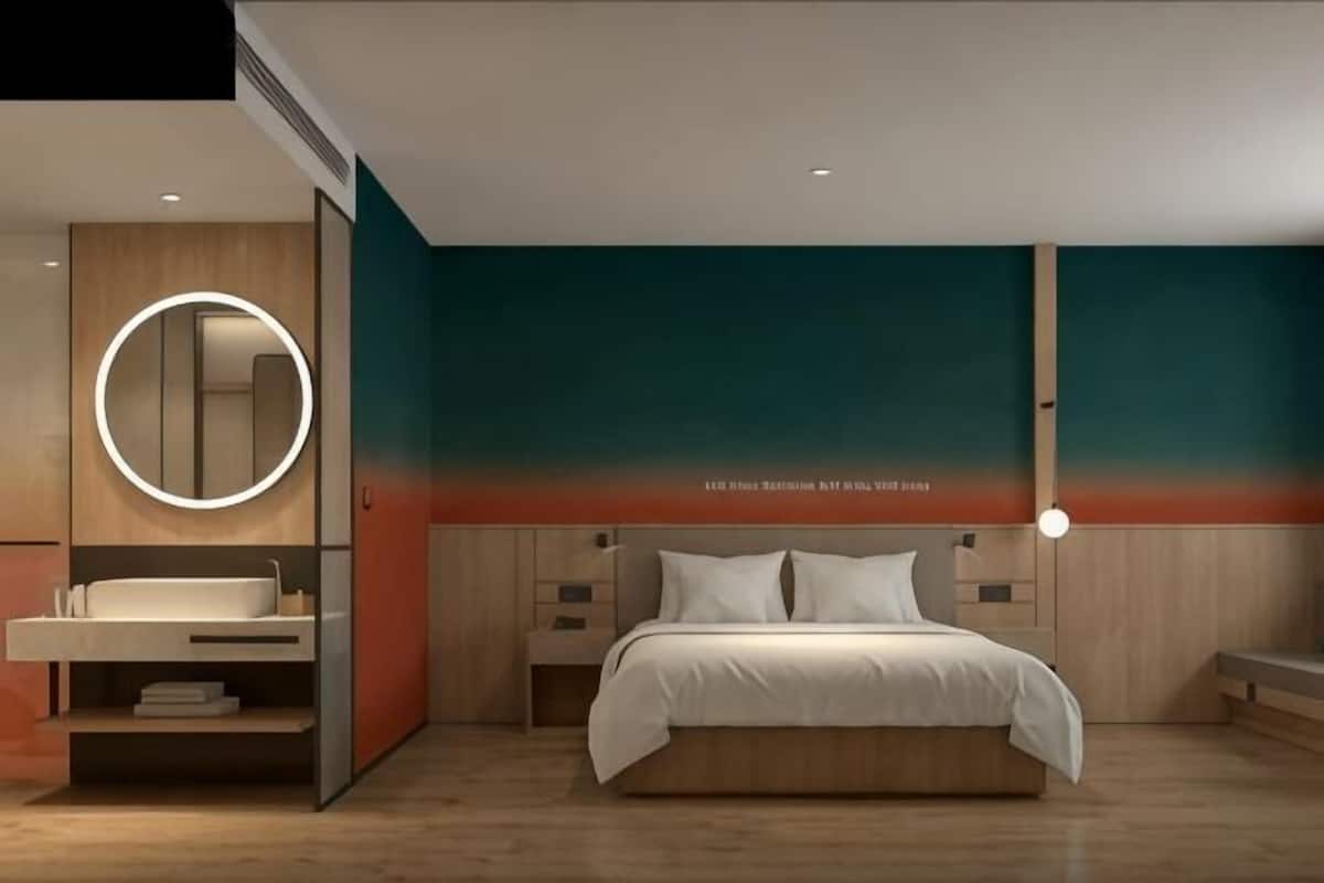 A modern bedroom with a bed, bedside table, and a circular mirror.
