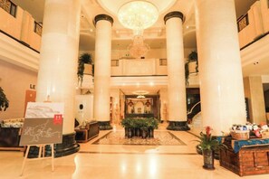 A grand lobby with high ceilings, large columns, and a central chandelier. - Himalaya Lhasa Hotel (Lhasa)