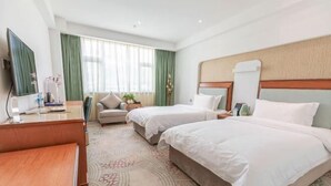 A hotel room with two beds, a desk, a TV, and a large window with curtains. - Himalaya Lhasa Hotel (Lhasa)