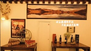 A room with a table displaying bottles and a framed picture on the wall. - Himalaya Lhasa Hotel (Lhasa)
