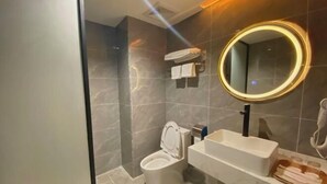 Une salle de bain moderne équipée de toilettes, d’un lavabo et d’un miroir.