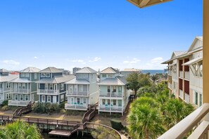A coastal residential area with multi-story houses featuring balconies and a view of the ocean.