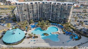 A large hotel with multiple floors, a central swimming pool, and surrounding amenities.