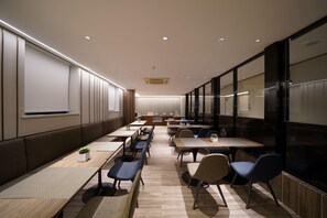 A conference room with long tables, chairs, and a large screen. - Hanting Hotel Guanglu, Wujiaochang, Shanghai (Shanghai)