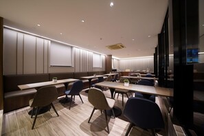 A modern conference room with tables, chairs, and a large screen. - Hanting Hotel Guanglu, Wujiaochang, Shanghai (Shanghai)