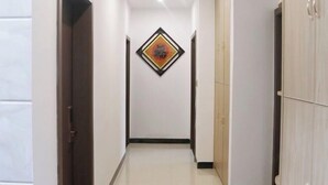 A hallway with a door on the left, a wardrobe on the right, and a framed artwork on the wall. - Mingjing Mountain House on the halfway of Hengshan Mountain (Hengyang)
