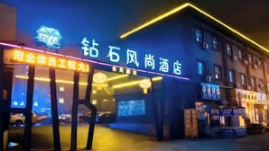 A hotel entrance with illuminated signage and a parking area. - Hebi Diamond Fashion Hotel (Changfeng Road Dwang Square Branch) (Hebi)