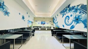 A hotel lobby with a long reception desk, black cushioned seating, and floral wall art. - Hebi Diamond Fashion Hotel (Changfeng Road Dwang Square Branch) (Hebi)