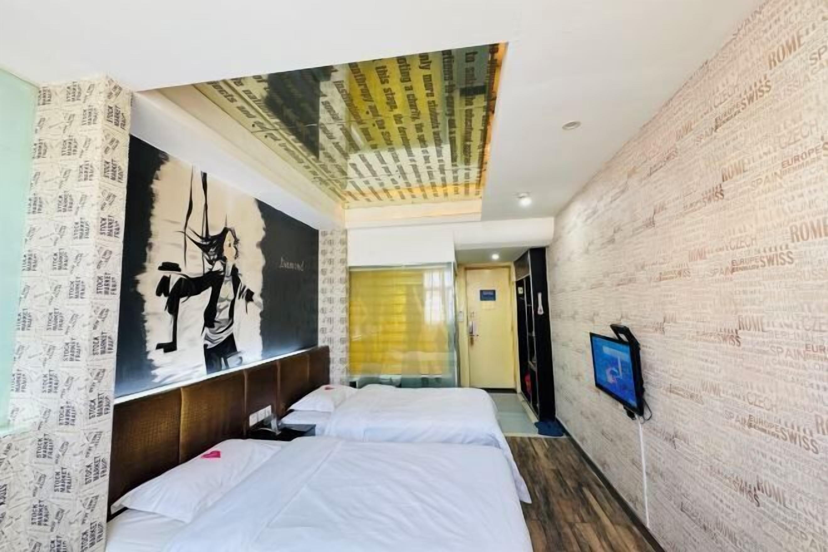 Ein Hotelzimmer mit zwei Betten, einem großen abstrakten Gemälde an der Wand und einer Decke mit einem gemusterten Design.