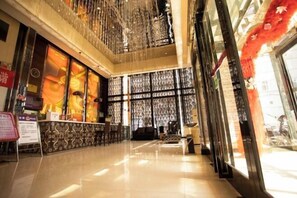 A spacious lobby with a reception desk, seating area, and a decorative wall with patterned curtains. - Hebi Diamond Fashion Hotel (Changfeng Road Dwang Square Branch) (Hebi)