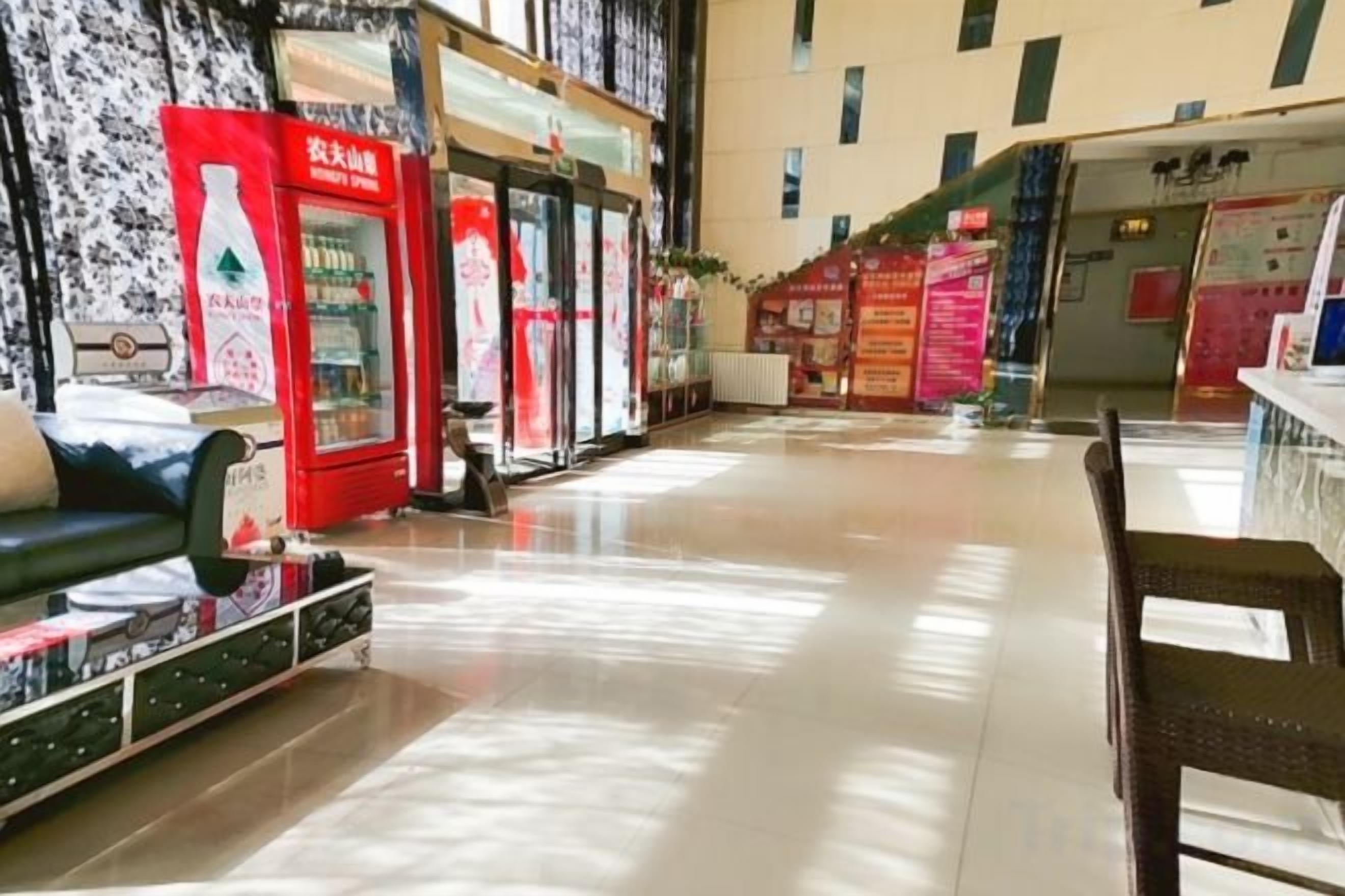A hotel lobby with seating areas, vending machines, and a reception desk.