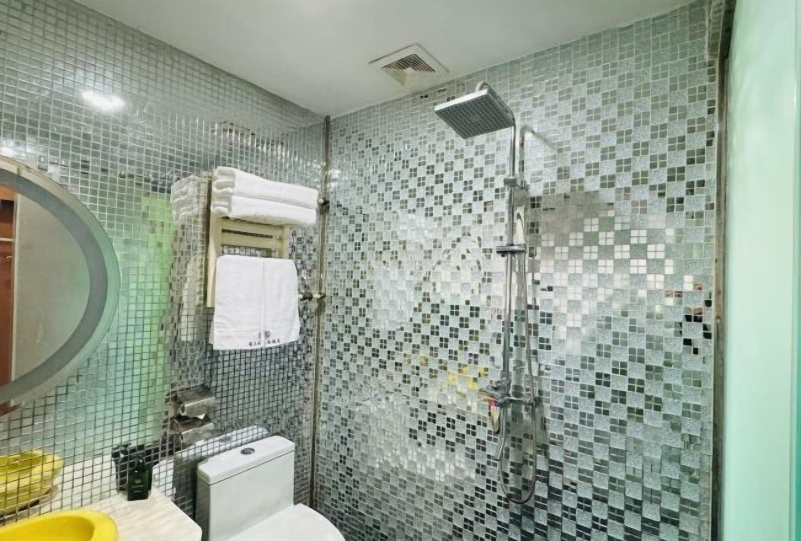 A bathroom with a shower, a toilet, and a sink.