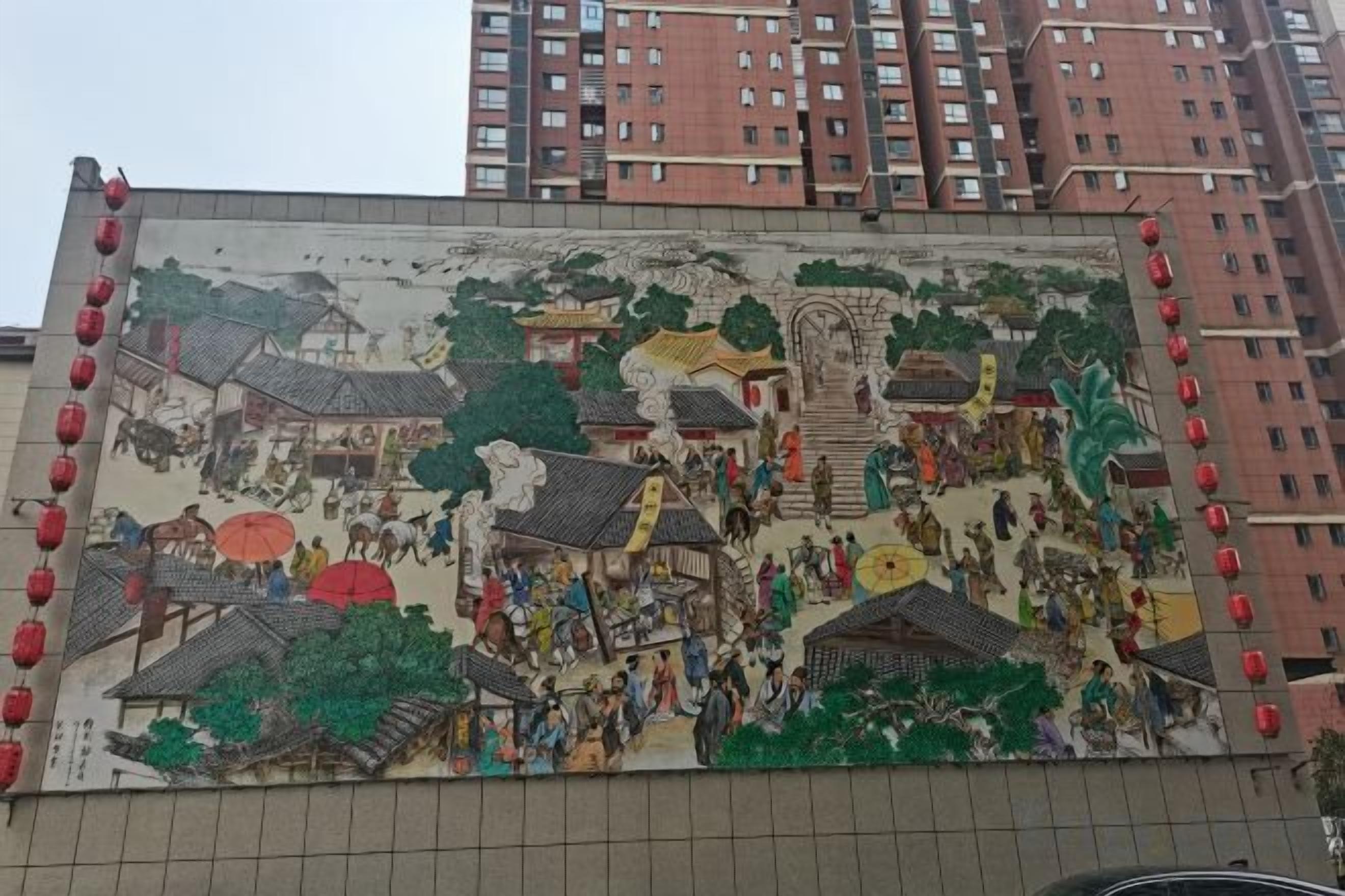 A mural with traditional architecture and figures, set against a building facade.
