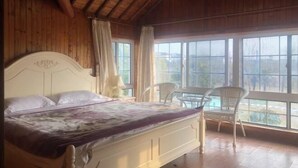 A wooden-paneled room with a bed, two chairs, and large windows. - Dongping Resort (Shanghai)