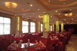 A banquet hall with round tables, red tablecloths, and tall pillars. - Dongping Resort (Shanghai)