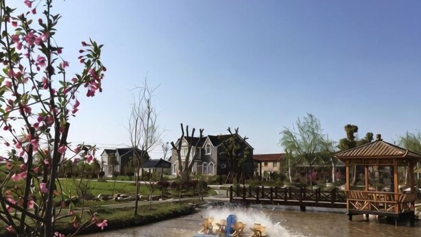 A water fountain with a gazebo in a park setting. - Dongping Resort (Shanghai)