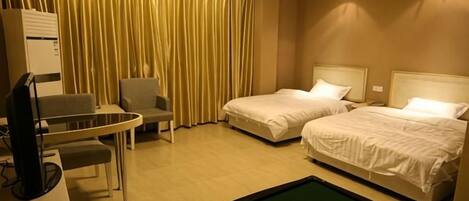 Quarto de hotel com duas camas, uma escrivaninha com cadeira, mesa de bilhar e uma janela grande com cortinas.