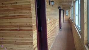 A wooden hallway with a door, windows, and wall-mounted lights. - Dongping Resort (Shanghai)